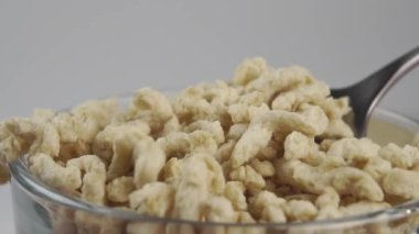Soya taneleri kaşıktan yavaş çekimde bir yığın halinde şeffaf bir kaba düşer. Döndürme Makro Vuruşu