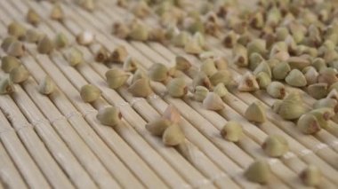 Bambu desenli paspasın üzerinde pişmemiş yeşil karabuğday. Dolly vurdu. Makro