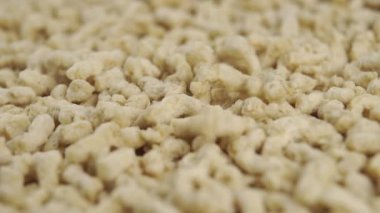 Dokulu soya tanecikleri yavaş çekimde yığının içine düşer. Makro. Vejetaryen et analoğu. Dolly vurdu.