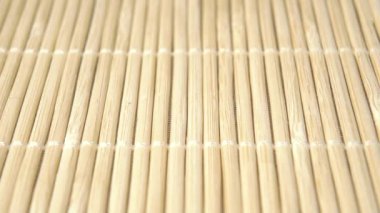 Kurutulmuş yeşil kenevir çayı yaprakları. Yavaş çekimde bambu paspasın üstüne düşmek. Makro