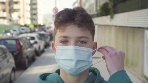 Tonåring Sätter Sig Medicinsk Skyddsmask Stadsgata Med Biltrafik Och Parkering — Stockvideo