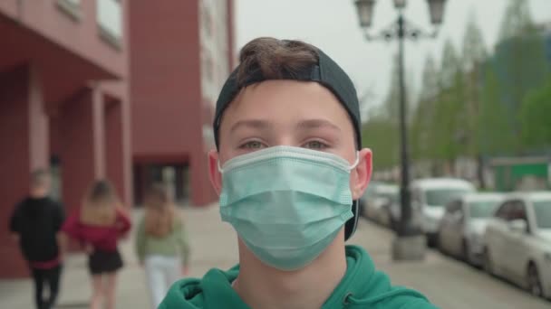 Подросток Защитной Медицинской Маске Бейсболке Улице Людьми Идущими Время Пандемии — стоковое видео