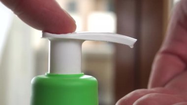 El dezenfektanı plastik konteynırın dağıtıcısına basılarak avuç içine sıkıştırılır. Deriyi silmek ve koronavirüs salgınını önlemek için alkol jeli, COVID-19