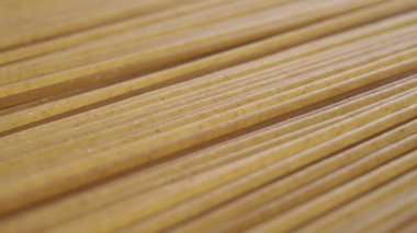 Geometrik paralel şekilde istiflenmiş ham integral spagettisinin makro desenli yüzeyi. Dolly vurdu. Geleneksel İtalyan Akdeniz mutfağı