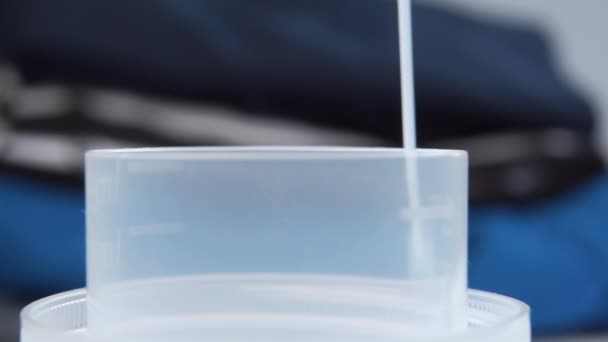 Detergente Líquido Azul Vierte Una Tapa Medición Palstica Contra Telón — Vídeos de Stock