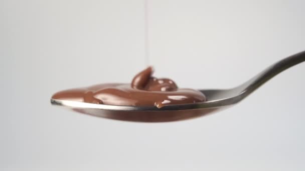 Schokoladenmousse Fließt Mit Spritzern Einen Metallenen Teelöffel Auf Weißem Hintergrund — Stockvideo