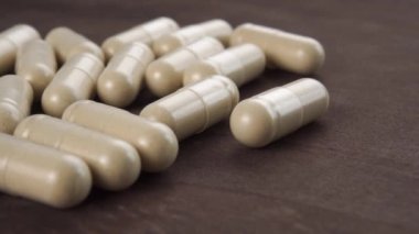 Alternatif tıp bitkisel tıbbi kapsülleri kapatın. Koyu ahşap arka plan. Makro. Doli Vuruşu