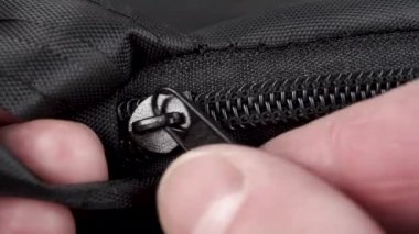 Siyah dişli bir fermuarı açıyorum. Makro çekim