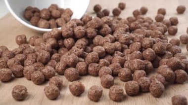 Tahta bir mutfak tahtasına saçılmış gevrek çikolata gevrekleri. Makro. Dolly vurdu. Çocuklar için tatlı kahvaltı fikri