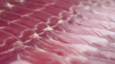 Yakın planda dilimlenmiş İber jamonu. Geleneksel İspanyol eti lezzeti. Makro. Dolly vurdu.