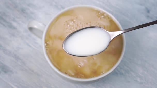 Egy Kanál Tej Közelről Egy Csésze Friss Forró Tea Mellett — Stock videók