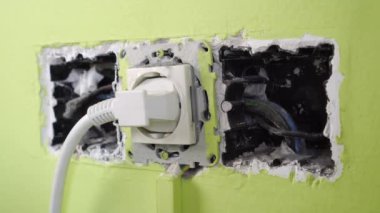 Bir el, odadaki bozuk bir elektrik prizinin fişini çeker. Bozuk eski, tehlikeli ev aletleri. Eski tozlu kablolar