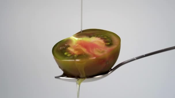 채소로 올리브유를 반갈색의 토마토 붓습니다 동작으로 늘인다 배경에 금속제 스푼을 — 비디오