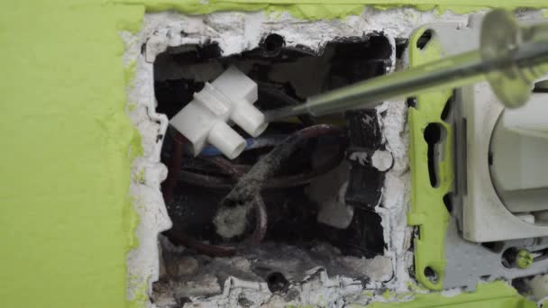 ほこりの多いワイヤーで壊れた古い危険な壁の出口で欠陥を見つける 高圧だ ドライバー電動テスターを使用する — ストック動画