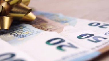 Altın yay süslemeli para. Yakın plan. Avro parası. Makro. Dolly vurdu. Tatil finansal hediye konsepti