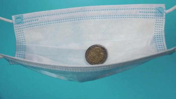 Europäische Münzen Fallen Zeitlupe Eine Medizinische Schutzmaske Blauer Hintergrund Nahaufnahme — Stockvideo