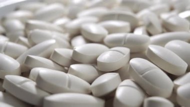 Bir yığın beyaz oval tıbbi ilaç hapları. Makro. Doli Vuruşu