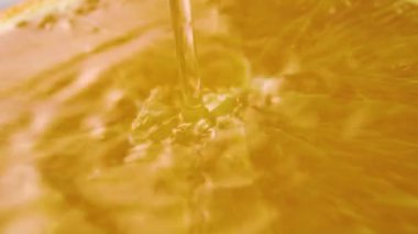 Saf su ağır çekimde portakal dilimine akar. Sıvı akış ve makro çekimde sıçrama
