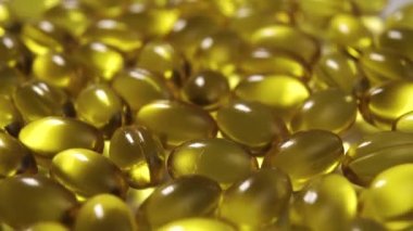 Somon yağı ve Omega 3 hapları dönüşümlü. Makro atış. Sarı tıbbi kapsüller