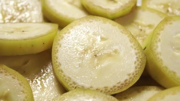 Reife Ungeschälte Scheiben Geschnittene Banane Gelbe Fruchtstücke Mit Schale Rotieren — Stockvideo