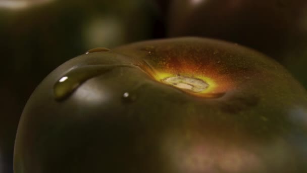 ゆっくりとした動きで熟したクマトトマトに澄んだ水の滴が落ちる マクロショット 暗い野菜の上に滴下 — ストック動画