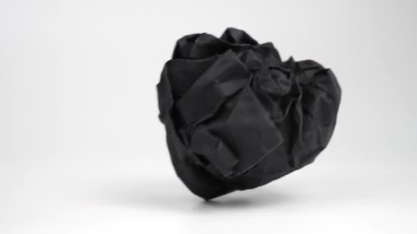 Černý Zmačkaný Papírový Balík Padá Kutálí Bílém Povrchu Záhyby Vrásky — Stock video