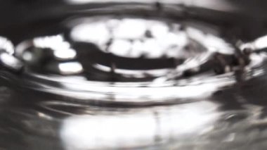 Chia tohumları parlak cam bir yüzeye yavaş çekimde dağılır. Makro. Döndürme