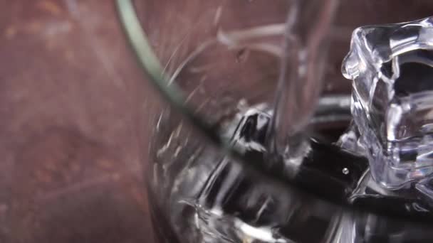 将纯净的水倒入一个装有冰冻冰块的杯子 缓慢地在木制表面上运动 多莉开枪了轮调 — 图库视频影像