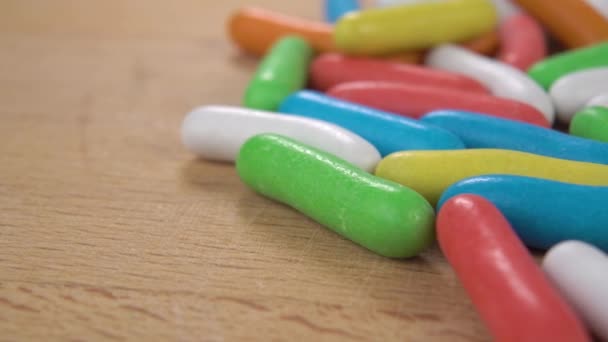 Doce Colorido Com Esmalte Gostoso Multicolorido Uma Superfície Madeira Macro — Vídeo de Stock