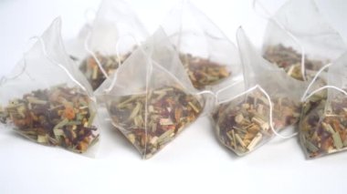 A group of micro plastic tea bags of floral fruit herbal tea. Close-up. Dolly Shot