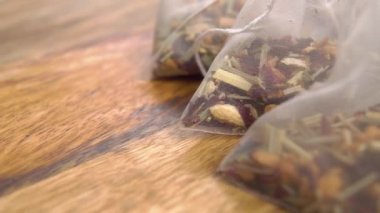 Kullanılmamış plastik bitki çayı poşetleri dokuma tahtasında. Makro. Dolly vurdu..