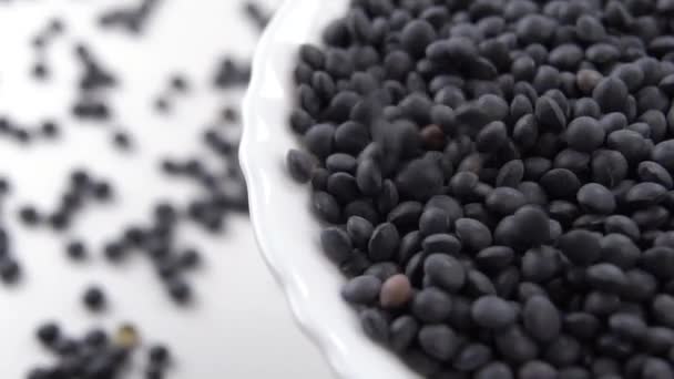 Black Beluga Lentil Fall Heap Full White Bowl Slow Motion — Stock Video