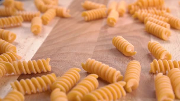 Färgad Vegetabilisk Linspasta Papperskopp Faller Hög Ett Träbord Slow Motion — Stockvideo