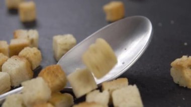 Taze kızarmış ekmek ekmeği, bir çay kaşığının içine düşer. Mutfak yüzeyinde, yavaş çekimde. Makro