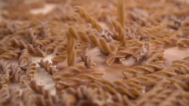 Vollkornweizen Rohe Pasta Die Einem Haufen Auf Eine Holzoberfläche Fällt — Stockvideo