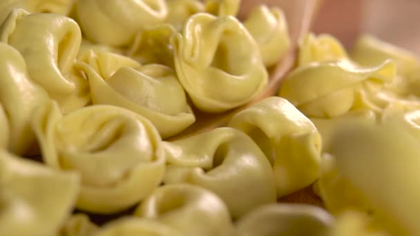 Raw Dry Italian Pasta Tortellini Full Wooden Spoon Falling Slow — Stock Video