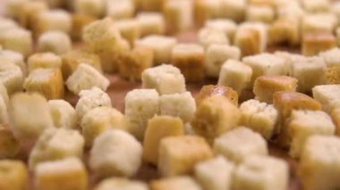 Kızarmış ekmek parçaları ağır çekimde ahşap bir yüzeye düşer. Makro çekim