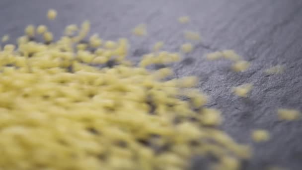 Roher Couscous Fällt Zeitlupe Auf Eine Schieferfarbene Küchenoberfläche Makroaufnahme — Stockvideo