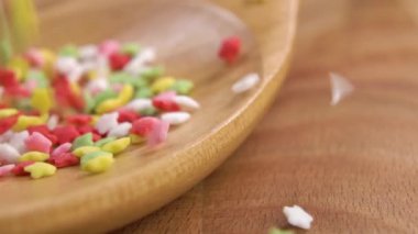 Dekoratif şekerli yıldız süslemeleri. Yavaş çekimde ahşap bir kaşığa tatlı bir fırın düşüşü. Makro çekim