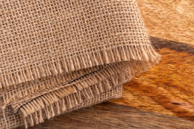 Ahşap bir yüzeyde dokuma dokusu olan, rostoskopik katlanmış çuval bezi. Kırsal malzeme. Boşluğu kopyala