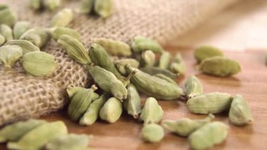 Kuru kakule tohumu kabukları kırsal çuval bezi ve yemek üzerinde. Makro. Dolly vurdu. Baharatlı doğulu baharat