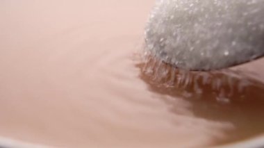 Kahveye şeker ekliyorum. Kristaller dolu kaşıktan yavaş çekimde içkiye dökülüyor. Makro çekim