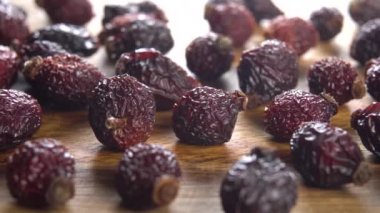 Ahşap bir yüzeyde kurumuş gül kalçaları. Makro. Doli Vuruşu