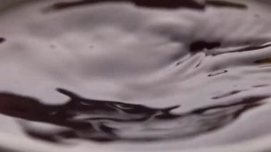 Çay fincanında demlenmiş siyah çay. Hareket eden parlak su yüzeyi. Ağır çekim. Makro