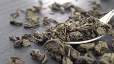 Kaşık içinde kuru yeşil çay yaprakları. Makro.