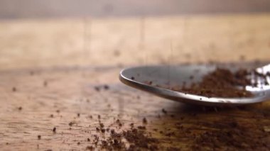 Kavrulmuş kahve yavaş çekimde bir çay kaşığının içine düşer. Makro. Dolly vurdu. Enerji içeceği.