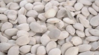 Kurutulmuş tuzlanmamış kabuk çekirdekleri kabukları ağır çekimde bir yığın içine düşer. Kapatın. Döndürme