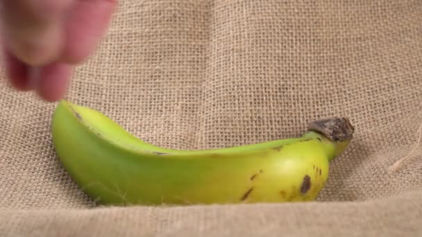 Eine Hand Nimmt Eine Frische Grüne Banane Aus Einem Rustikalen — Stockvideo