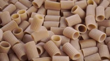 Pişmemiş rigatoni integral italyan makarnası yavaş çekimde düşer. Kapatın. Döndürme
