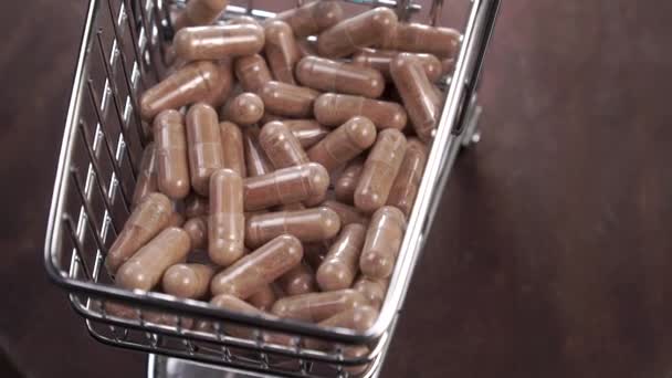 Voller Einkaufswagen Mit Medikamentenkapseln Auf Dunklem Holzgrund Aus Nächster Nähe — Stockvideo